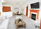Thumbnail 1 of 28 - a living room with a couch and a table and a fireplace