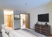 Thumbnail 11 of 28 - a bedroom with a bed and a dresser and a tv