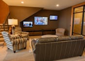 Thumbnail 3 of 53 - a living room with couches and chairs and televisions