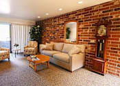 Thumbnail 4 of 12 - a living room with a brick wall and a couch