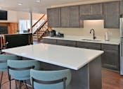 Thumbnail 20 of 28 - a kitchen with a white counter top and a stainless steel refrigerator