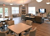 Thumbnail 3 of 26 - A large room with a fireplace and a TV on the wall.