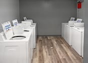 Thumbnail 21 of 26 - A row of washing machines in a laundromat.