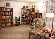 Thumbnail 43 of 49 - A room with a chair and a bookshelf filled with books.