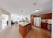 Thumbnail 30 of 36 - A kitchen with wooden cabinets and a stainless steel refrigerator.
