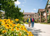 Thumbnail 1 of 28 - a couple walking down a sidewalk in front of an apartment building