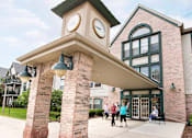 Thumbnail 1 of 20 - people walking outside of a building with a clock tower