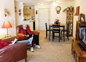 Thumbnail 1 of 6 - two people sitting in a living room watching tv