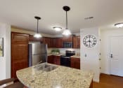 Thumbnail 16 of 28 - a kitchen with a granite counter top and a stainless steel refrigerator