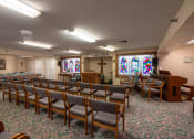 Thumbnail 2 of 28 - a church with chairs and a piano and a stained glass window