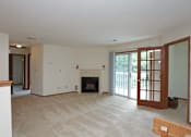 Thumbnail 5 of 14 - A living room with a fireplace and sliding glass doors.