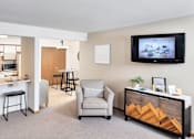 Thumbnail 10 of 14 - a living room with a tv and a kitchen with a bar and stools