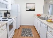 Thumbnail 13 of 28 - a white kitchen with a black and white rug