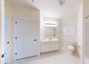 Thumbnail 53 of 59 - A white bathroom with a toilet, sink, and mirror.