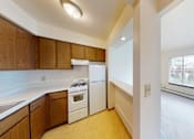 Thumbnail 8 of 10 - A kitchen with wooden cabinets and white appliances.