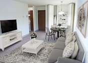 Thumbnail 8 of 16 - a living room and dining room with a couch and a television