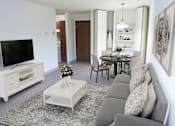 Thumbnail 7 of 12 - a living room and dining room with a couch and a television