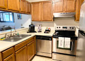 Thumbnail 27 of 50 - a kitchen with stainless steel appliances and wooden cabinets