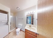 Thumbnail 13 of 50 - A small bathroom with a toilet, sink, and a small refrigerator.