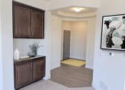 Thumbnail 18 of 64 - a living room with wooden cabinets and a hallway leading to a door to a bathroom