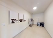 Thumbnail 46 of 64 - A room with a white wall and a picture of a dog hanging on it.