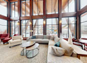 Thumbnail 52 of 64 - A large room with a long couch and a table in front of a large window.