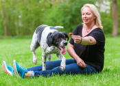 Thumbnail 27 of 28 - a woman sitting on the grass with her dog