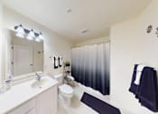 Thumbnail 57 of 65 - A bathroom with a white sink and a white toilet.