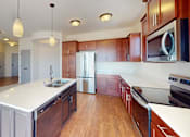 Thumbnail 36 of 53 - A kitchen with wooden cabinets and a white countertop.