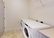 Thumbnail 46 of 53 - A white washing machine in a laundry room.