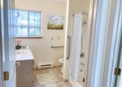 Thumbnail 19 of 22 - a bathroom with a shower and a sink and a toilet