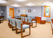 Thumbnail 10 of 22 - a seating area in a church with chairs and a podium