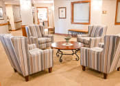 Thumbnail 7 of 22 - a living room with striped chairs and a table