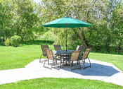 Thumbnail 4 of 22 - a patio with a table and chairs and an umbrella