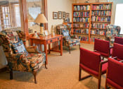 Thumbnail 3 of 22 - a living room filled with chairs and a table with books