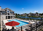 Thumbnail 31 of 53 - a pool with a red umbrella in front of a house