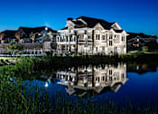 Thumbnail 23 of 53 - a large building reflected in a pond at night