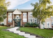 Thumbnail 20 of 28 - an apartment building with a lawn and trees in front of it
