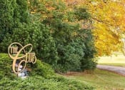 Thumbnail 1 of 28 - a sign in a grassy area with trees in the background