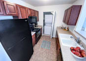 Thumbnail 5 of 26 - a kitchen with a black refrigerator freezer next to a sink