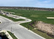 Thumbnail 24 of 25 - an aerial view of a field of grass with an airport runway in the foreground