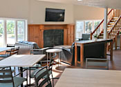Thumbnail 19 of 28 - an open living room with tables and chairs and a fireplace