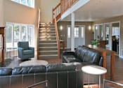 Thumbnail 21 of 28 - an open living room with leather furniture and a staircase