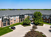 Thumbnail 5 of 14 - an aerial view of an apartment building with a parking lot
