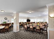 Thumbnail 10 of 14 - a large dining room with tables and chairs and a television