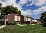 Thumbnail 25 of 31 - a row of apartment buildings with lawns and trees