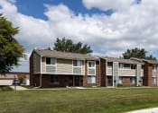 Thumbnail 24 of 31 - a row of apartment buildings with grass and trees