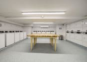 Thumbnail 18 of 47 - a large room with white cabinets and a table in the middle