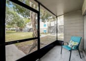 Thumbnail 15 of 47 - screened in porch with blue chair and large windows overlooking the yard