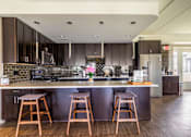 Thumbnail 101 of 124 - A kitchen with a bar area and two stools.